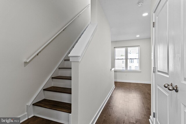 staircase featuring wood finished floors, baseboards, and recessed lighting