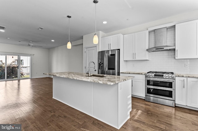 kitchen featuring wall chimney range hood, stainless steel appliances, tasteful backsplash, white cabinets, and recessed lighting