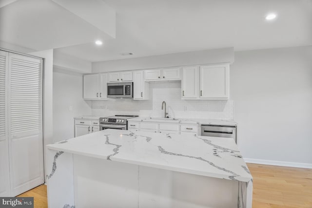 8118 Chapel Cove Dr, Laurel, MD 20707 - kitchen with stainless steel appliances, a sink, white cabinetry, light wood finished floors, and recessed lighting