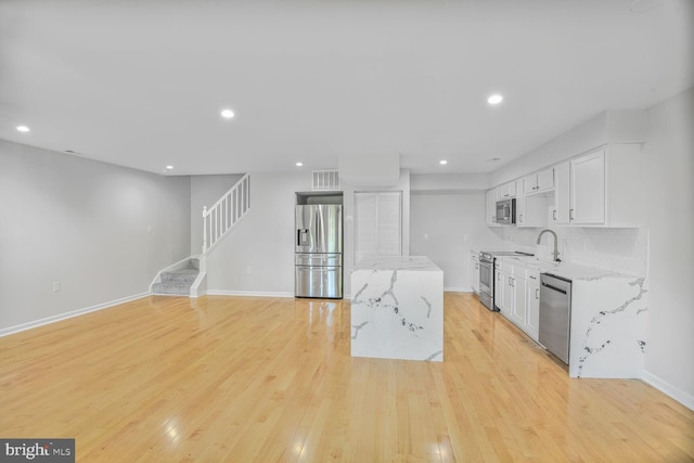 8118 Chapel Cove Dr, Laurel, MD 20707 - kitchen featuring stainless steel appliances, light stone countertops, white cabinets, light wood-style flooring, and recessed lighting
