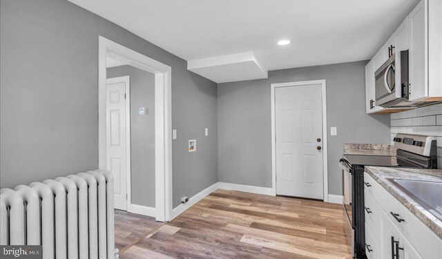 212 Broad St, Elmer, NJ 08318 - kitchen with radiator, appliances with stainless steel finishes, baseboards, light wood-style flooring, and white cabinets