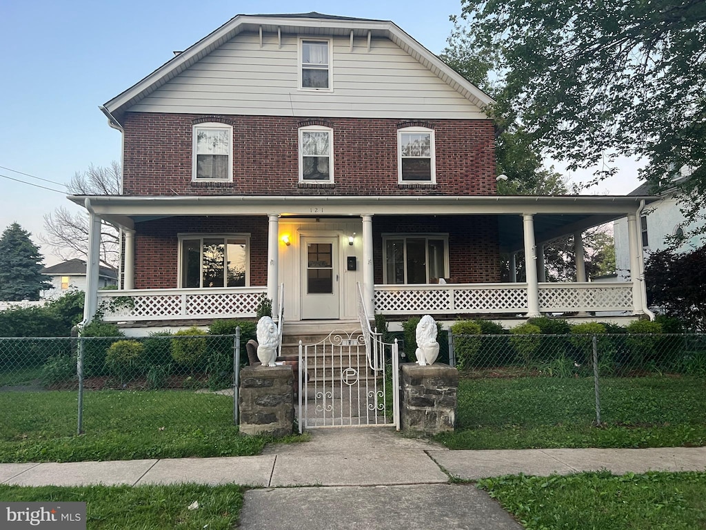 121 Penn Blvd, Lansdowne, PA 19050 - view of front facade featuring a porch, brick siding, and a gate