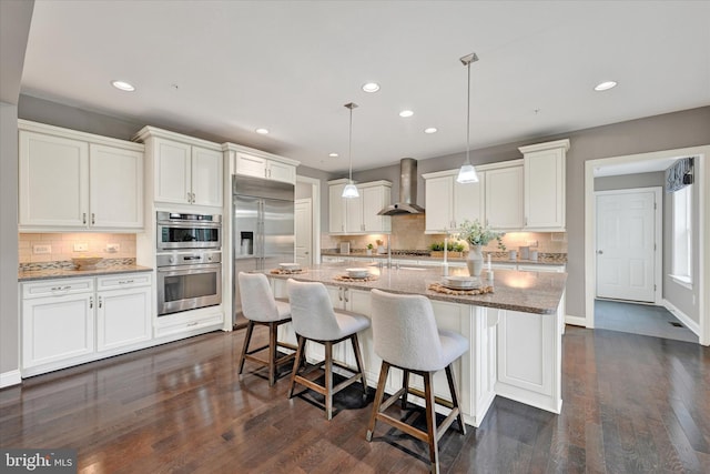 9830 Forge Valley Ct, Perry Hall, MD 21128 - kitchen with wall chimney exhaust hood, backsplash, an island with sink, recessed lighting, and white cabinetry