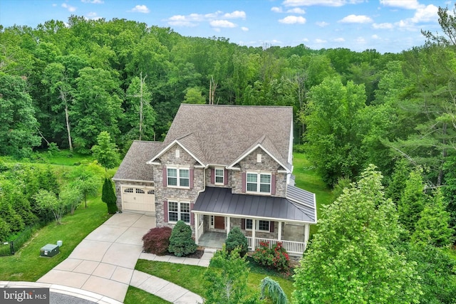 9830 Forge Valley Ct, Perry Hall, MD 21128 - craftsman-style house with stone siding, covered porch, concrete driveway, and a wooded view