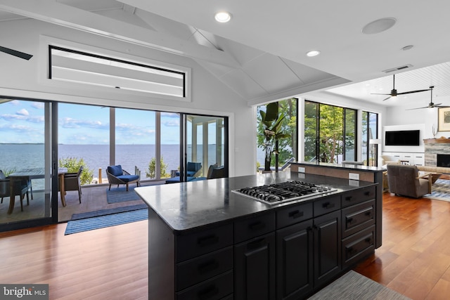 2514 Lyon Dr, Annapolis, MD 21403 - kitchen featuring dark cabinetry, open floor plan, lofted ceiling, wood finished floors, and stainless steel gas cooktop