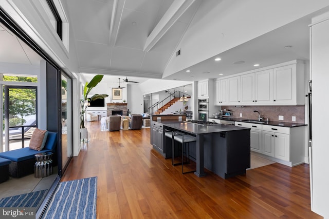 2514 Lyon Dr, Annapolis, MD 21403 - kitchen featuring dark countertops, a sink, backsplash, white cabinets, and open floor plan