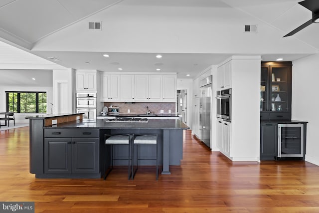 2514 Lyon Dr, Annapolis, MD 21403 - kitchen with beverage cooler, stainless steel appliances, a sink, white cabinets, and wood finished floors