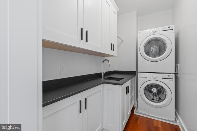 2514 Lyon Dr, Annapolis, MD 21403 - laundry room featuring stacked washer / dryer, cabinet space, and dark wood-type flooring