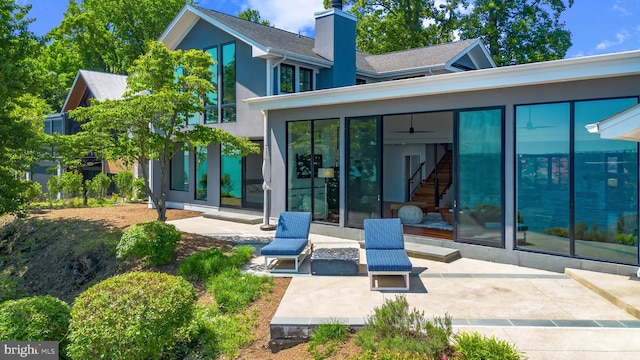2514 Lyon Dr, Annapolis, MD 21403 - rear view of house with a sunroom, a patio, a chimney, and stucco siding