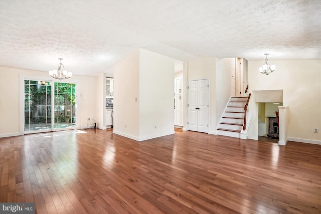 958 Tympani, Herndon, VA 20170 - unfurnished living room featuring a chandelier, a textured ceiling, hardwood / wood-style flooring, and stairway