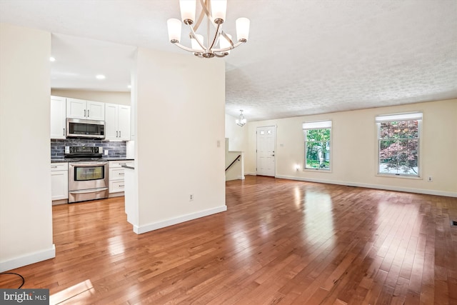 958 Tympani, Herndon, VA 20170 - unfurnished living room featuring a chandelier, light wood-style floors, and baseboards