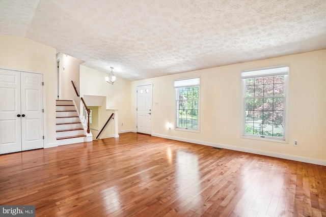 958 Tympani, Herndon, VA 20170 - foyer entrance featuring hardwood / wood-style flooring, a textured ceiling, baseboards, a chandelier, and stairway