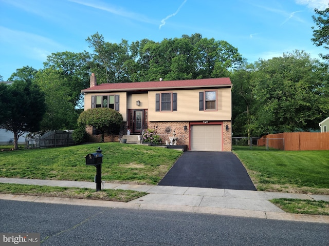 bi-level home featuring a chimney, brick siding, driveway, and a garage