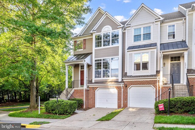 20580 Willoughby Sq, Sterling, VA 20165 - townhome / multi-family property with concrete driveway, brick siding, a standing seam roof, a garage, and metal roof