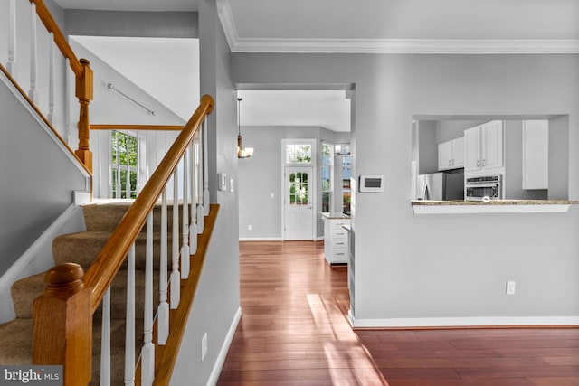 20580 Willoughby Sq, Sterling, VA 20165 - stairs featuring wood-type flooring, healthy amount of natural light, ornamental molding, and baseboards
