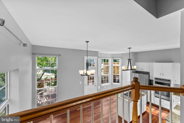 20580 Willoughby Sq, Sterling, VA 20165 - corridor with wood finished floors, a chandelier, and an upstairs landing