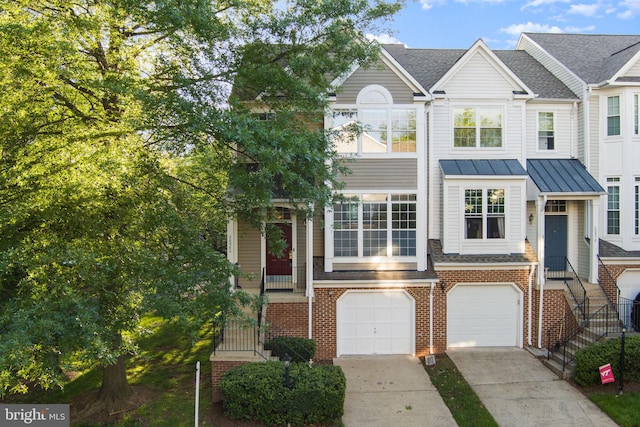 20580 Willoughby Sq, Sterling, VA 20165 - townhome / multi-family property featuring concrete driveway, brick siding, an attached garage, a standing seam roof, and metal roof
