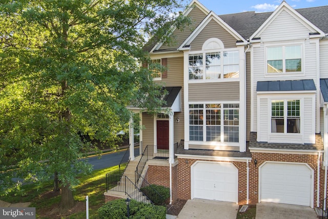 20580 Willoughby Sq, Sterling, VA 20165 - townhome / multi-family property featuring an attached garage, brick siding, a shingled roof, driveway, and a standing seam roof