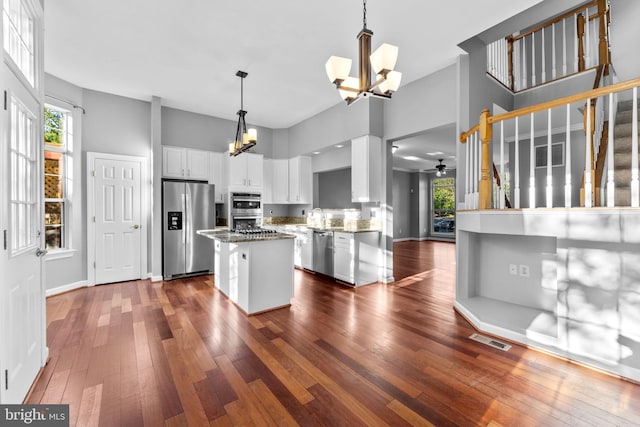 20580 Willoughby Sq, Sterling, VA 20165 - kitchen featuring stainless steel appliances, a chandelier, dark wood-style floors, white cabinets, and a center island