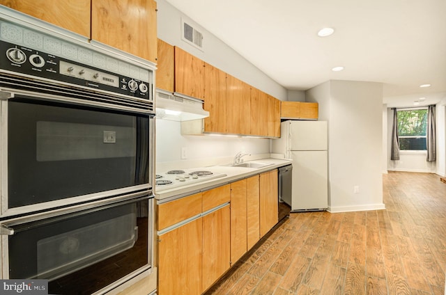 1726 U St NW Unit 1, Washington, DC 20009 - kitchen featuring under cabinet range hood, light wood-type flooring, white appliances, light countertops, and a sink