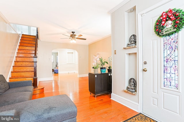4719 Rorer St, Philadelphia, PA 19120 - foyer entrance with arched walkways, light wood-style floors, crown molding, ceiling fan, and stairway