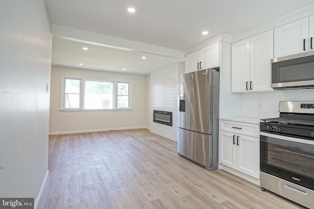 110 3rd St, Brooklawn, NJ 08030 - kitchen featuring stainless steel appliances, white cabinets, light wood-style flooring, baseboards, and backsplash