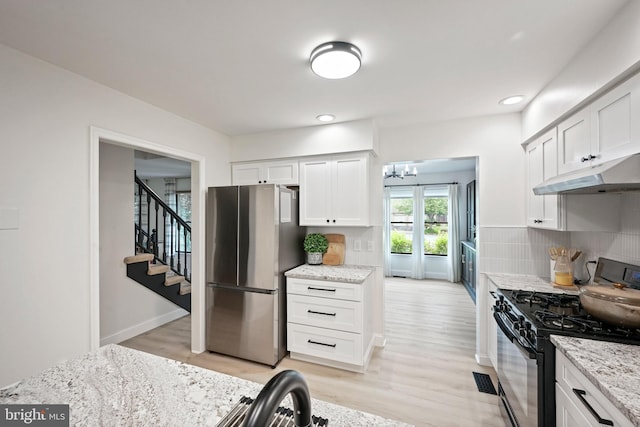329 Hunter Path Rd, Hummelstown, PA 17036 - kitchen with freestanding refrigerator, black range with gas stovetop, under cabinet range hood, light wood-type flooring, and recessed lighting