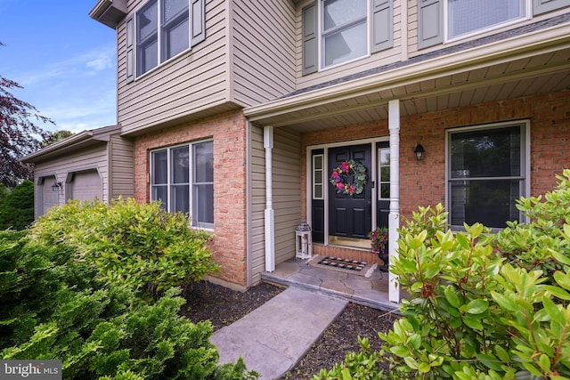 329 Hunter Path Rd, Hummelstown, PA 17036 - view of exterior entry featuring an attached garage, brick siding, and covered porch