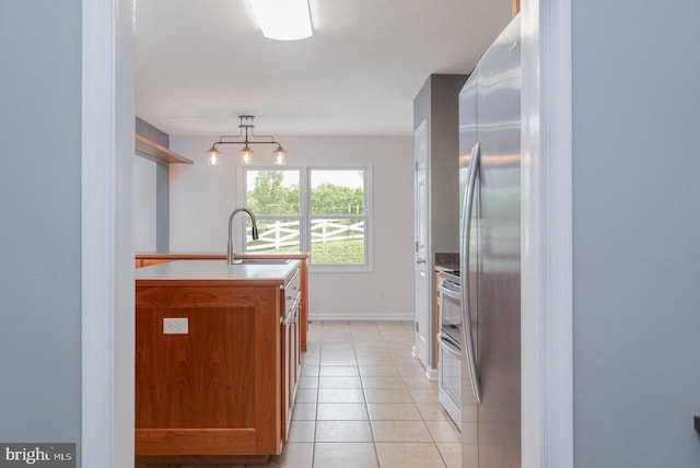 6081 Dotts Ln, Penn Laird, VA 22846 - kitchen featuring double oven range, a sink, brown cabinetry, light tile patterned floors, and hanging light fixtures