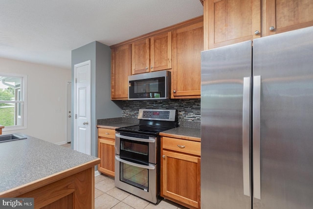 6081 Dotts Ln, Penn Laird, VA 22846 - kitchen with stainless steel appliances, backsplash, light tile patterned floors, and brown cabinets