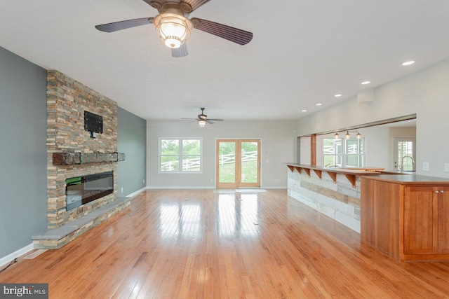 6081 Dotts Ln, Penn Laird, VA 22846 - unfurnished living room featuring a ceiling fan, a fireplace, light wood finished floors, a sink, and baseboards