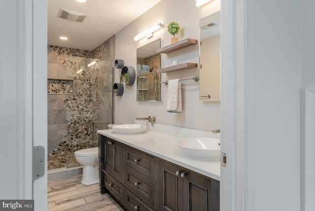 6081 Dotts Ln, Penn Laird, VA 22846 - bathroom featuring double vanity, a tile shower, wood finished floors, toilet, and recessed lighting