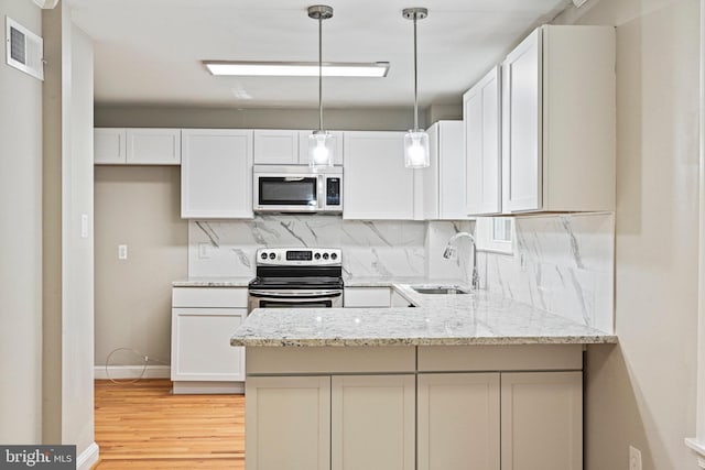 2249 Gunsmith Sq, Reston, VA 20191 - kitchen featuring appliances with stainless steel finishes, a sink, tasteful backsplash, and light wood finished floors