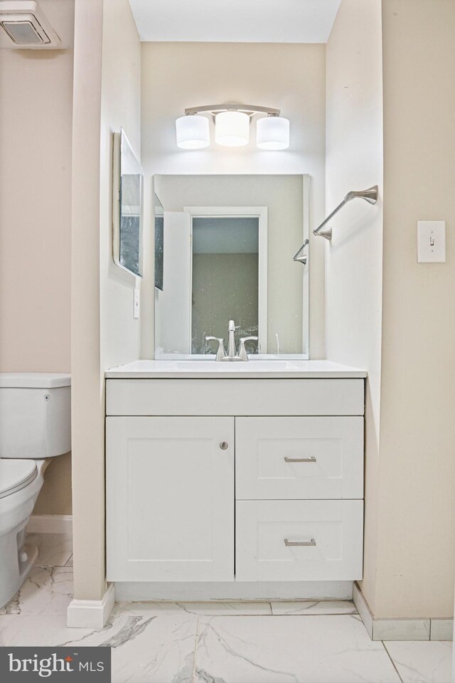 2249 Gunsmith Sq, Reston, VA 20191 - bathroom with marble look tile flooring, toilet, baseboards, and vanity