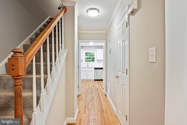 2249 Gunsmith Sq, Reston, VA 20191 - hall with light wood finished floors, ornamental molding, stairway, and a sink