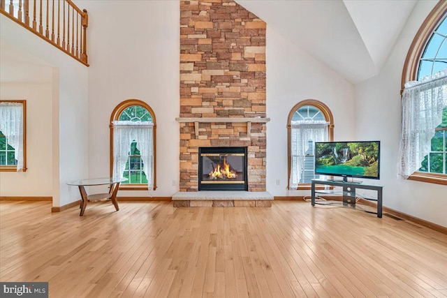 280 Center Rd, Lehighton, PA 18235 - unfurnished living room with high vaulted ceiling, hardwood / wood-style flooring, a stone fireplace, and baseboards