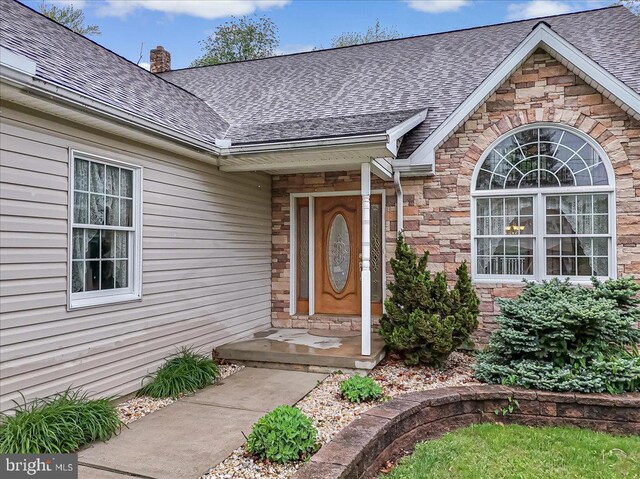 280 Center Rd, Lehighton, PA 18235 - view of exterior entry with a shingled roof, stone siding, and a chimney