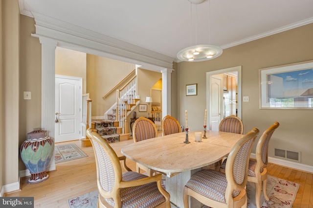 1015 Riverview Ln, Conshohocken, PA 19428 - dining room with ornate columns, light wood-style floors, stairway, crown molding, and baseboards