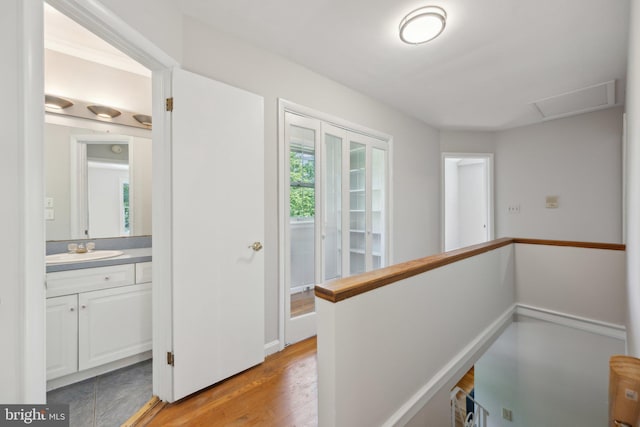 3538 Yuma St NW, Washington, DC 20008 - corridor featuring a sink, light wood-style flooring, and an upstairs landing