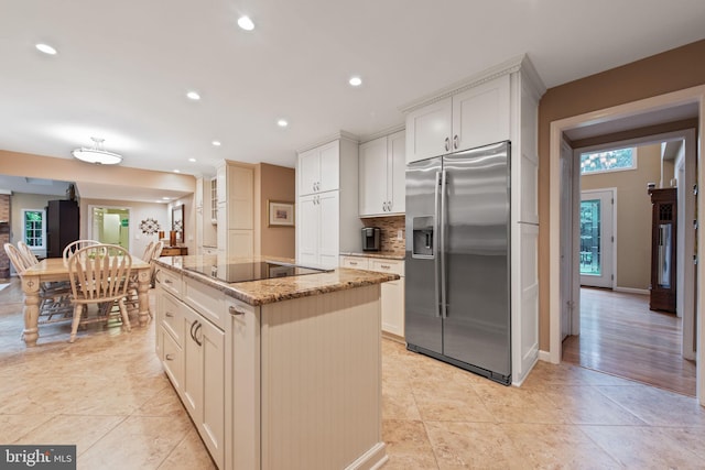 6323 Colchester Rd, Fairfax Station, VA 22039 - kitchen with stainless steel fridge with ice dispenser, light stone counters, a center island, decorative backsplash, and recessed lighting