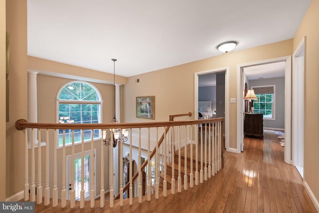6323 Colchester Rd, Fairfax Station, VA 22039 - hallway with wood-type flooring, healthy amount of natural light, a chandelier, and an upstairs landing