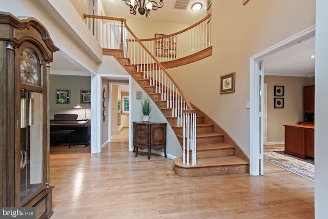 6323 Colchester Rd, Fairfax Station, VA 22039 - staircase featuring wood finished floors, a high ceiling, baseboards, a chandelier, and crown molding