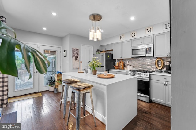1420 V St SE, Washington, DC 20020 - kitchen featuring stainless steel appliances, a kitchen bar, light countertops, decorative backsplash, and recessed lighting
