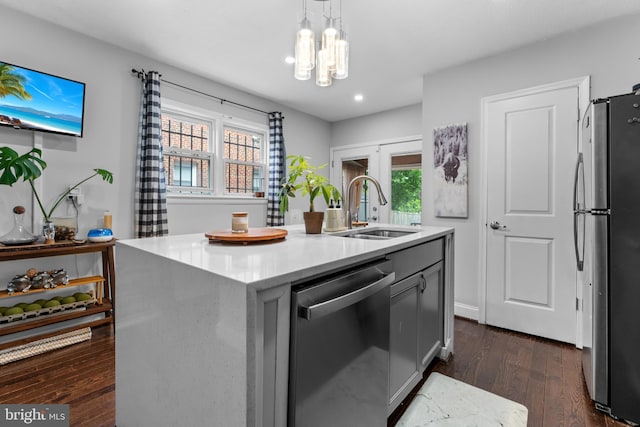 1420 V St SE, Washington, DC 20020 - kitchen featuring appliances with stainless steel finishes, a sink, dark wood-style floors, an island with sink, and hanging light fixtures