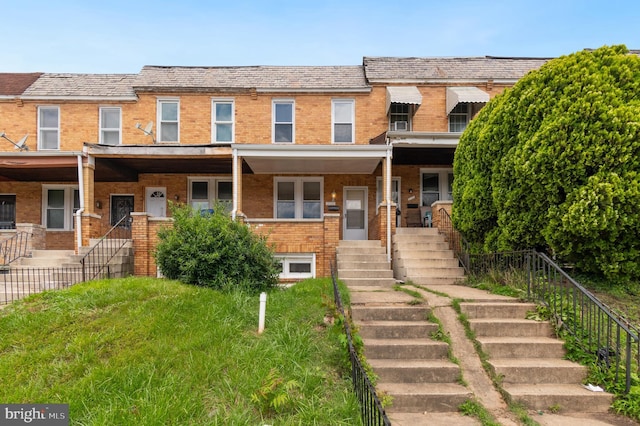 2726 E Preston St, Baltimore, MD 21213 - view of property featuring stairway, brick siding, a high end roof, and a porch
