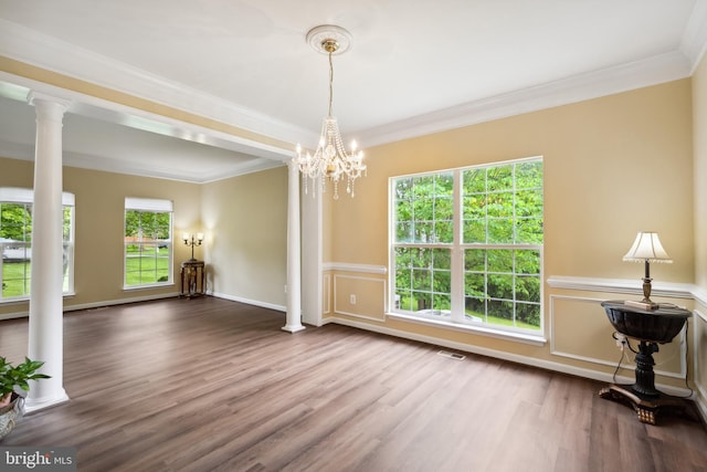8456 Summer Breeze Pl, Manassas, VA 20112 - empty room featuring decorative columns, crown molding, wood finished floors, wainscoting, and a chandelier