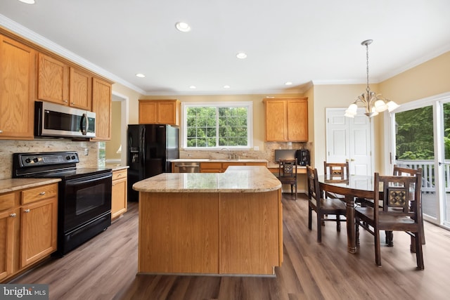 8456 Summer Breeze Pl, Manassas, VA 20112 - kitchen with black appliances, a chandelier, a center island, ornamental molding, and backsplash