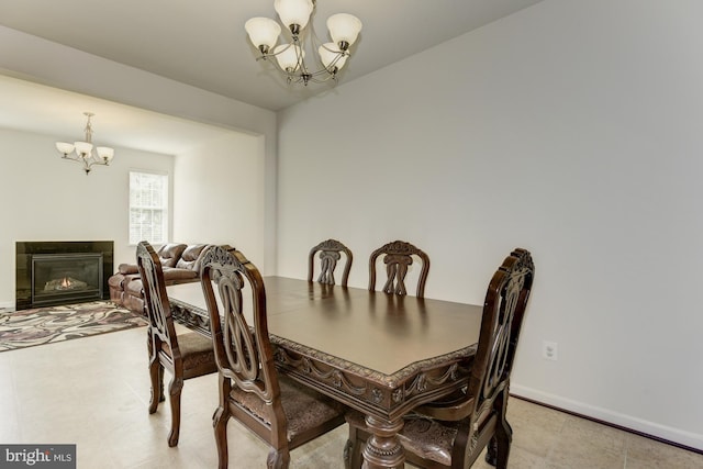 22672 Flowing Spring Sq, Brambleton, VA 20148 - dining area with a chandelier, baseboards, and a glass covered fireplace