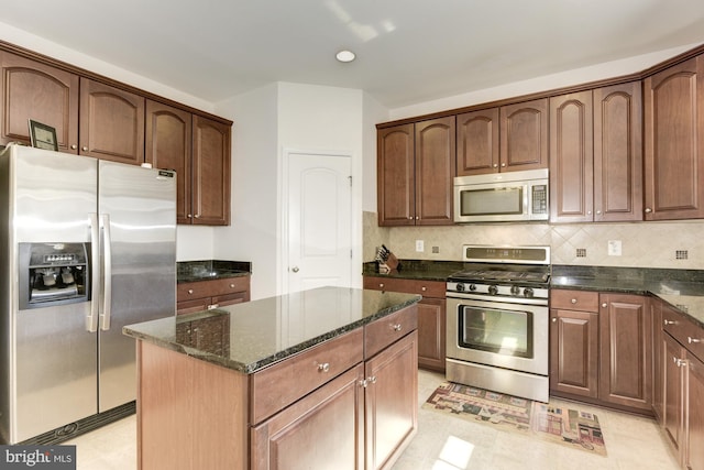 22672 Flowing Spring Sq, Brambleton, VA 20148 - kitchen featuring appliances with stainless steel finishes, dark stone countertops, a center island, decorative backsplash, and light flooring