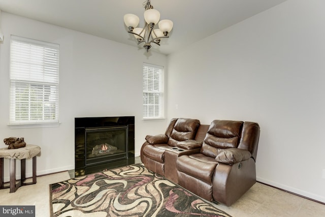 22672 Flowing Spring Sq, Brambleton, VA 20148 - living area with a chandelier, plenty of natural light, baseboards, and a glass covered fireplace